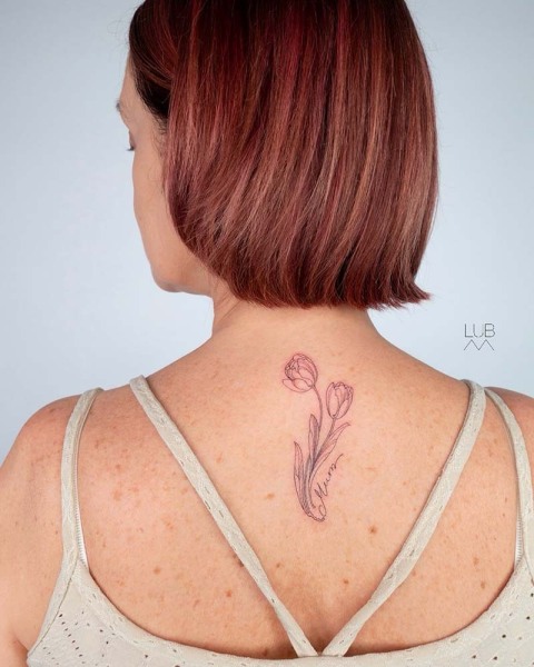A timeless tribute: This custom fine-line tulip and 'Mum' script piece by Lubava celebrates delicate botanical art and personal storytelling.
