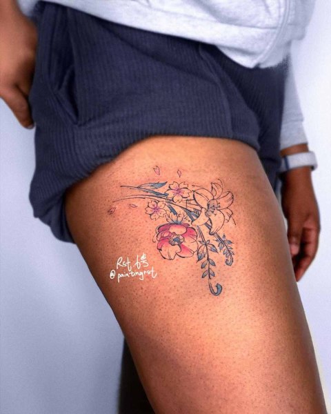 Delicate cherry blossom and lily thigh tattoo by guest artist Peng at Silent Moon, our private tattoo studio in Bermondsey, South East London.