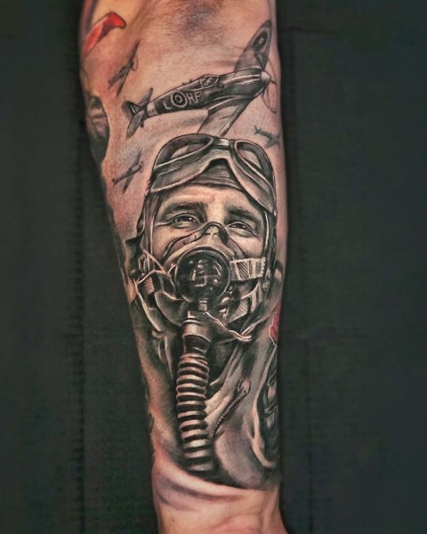 Black and grey realism WWII pilot and Spitfire tattoo by Klaudia at Silent Moon, our private tattoo studio in Bermondsey, South East London.