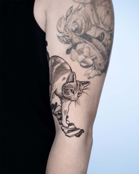 Fine line cat and piano tattoo by Robin at Silent Moon, our private tattoo studio in Bermondsey, South East London.