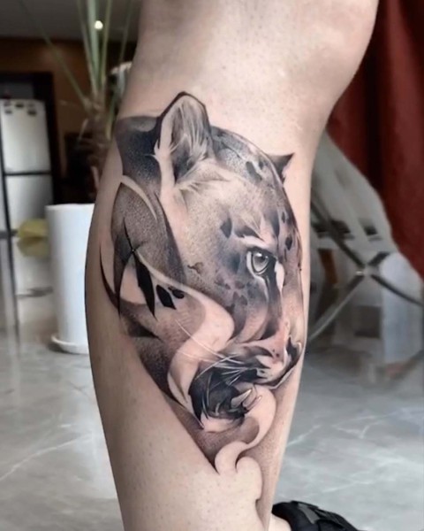 Black and grey snow leopard calf tattoo by Satrxx at Silent Moon, our private tattoo studio in Bermondsey, South East London.