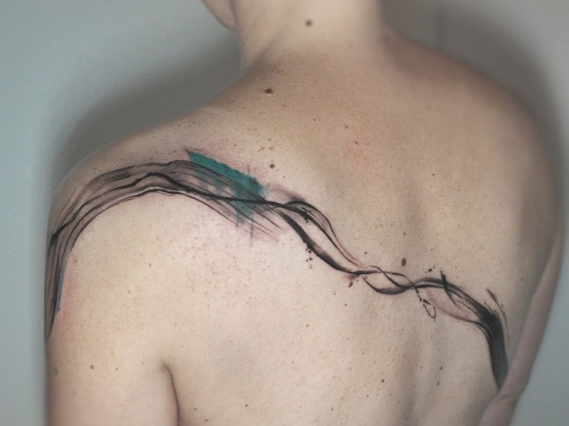 Minimal abstract brush stroke tattoo across the upper back by Klaudia at Silent Moon, our private tattoo studio in Bermondsey, South East London.