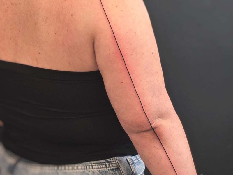 Minimal single line tattoo from back to wrist by Klaudia at Silent Moon, our private tattoo studio in Bermondsey, South East London.