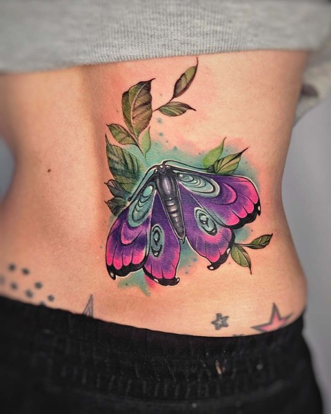 Neo-traditional purple moth lower back tattoo by Klaudia at Silent Moon, our private tattoo studio in Bermondsey, South East London.