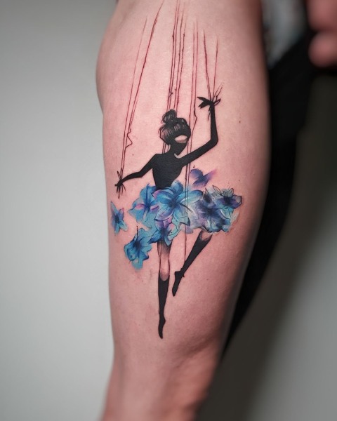 Watercolour marionette ballerina tattoo with a flower tutu by Klaudia at Silent Moon, our private tattoo studio in Bermondsey, South East London.