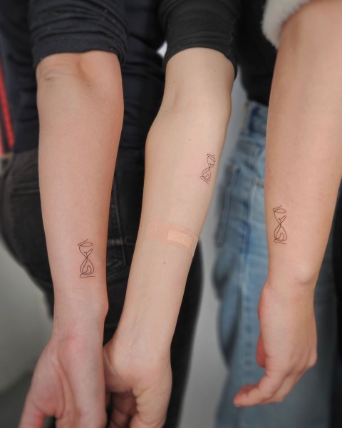 Matching fine line hourglass tattoos for three by Klaudia at Silent Moon, our private tattoo studio in Bermondsey, South East London.