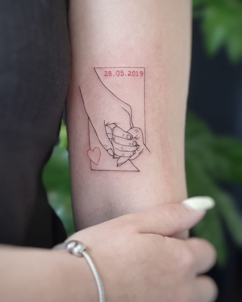 Fine line parent and baby hands tattoo by Klaudia at Silent Moon, our private tattoo studio in Bermondsey, South East London.