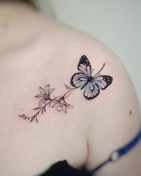 Fine line pastel butterfly and lily tattoo by Klaudia at Silent Moon, our private tattoo studio in Bermondsey, South East London.