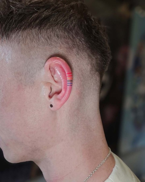 Fine line rainbow ear tattoo by Klaudia at Silent Moon, our private tattoo studio in Bermondsey, South East London.