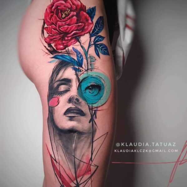 Abstract Realism Red Rose & Portrait Tattoo | Vibrant Thigh Art London Vibrant abstract realism tattoo on the thigh featuring a black and grey female portrait with closed eyes, a large red realism rose, and geometric blue/red abstract accents. Custom high-impact colour piece tattooed at Silent Moon Tattoo Studio in London.