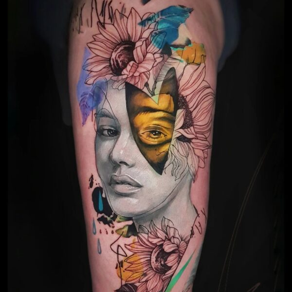 Abstract Realism Sunflower Portrait Tattoo | Vibrant Thigh Art London Vibrant abstract realism tattoo on the thigh featuring a female portrait with sunflower blackwork details, a golden abstract eye mask, and bold blue/yellow brushstrokes. Custom high-impact colour piece tattooed at Silent Moon Tattoo Studio in London.