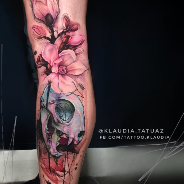 Abstract Colour Magnolia & Cat Skull Tattoo | Large Scale Art London Vibrant abstract colour tattoo on the calf featuring pink magnolia flowers above a stylized cat skull with blue and purple accents. Custom conceptual large-scale piece tattooed at Silent Moon Tattoo Studio in London