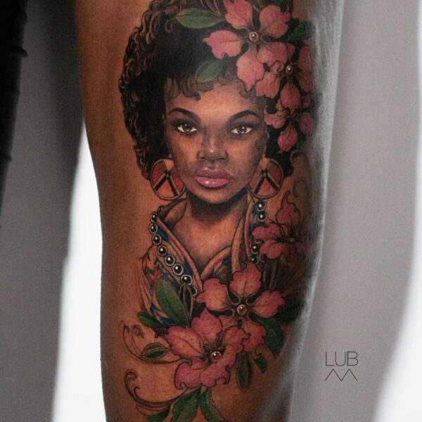 Portrait tattoo of woman with pink flowers and green leaves by tattoo artist at Silent Moon Tattoo Studio in London.