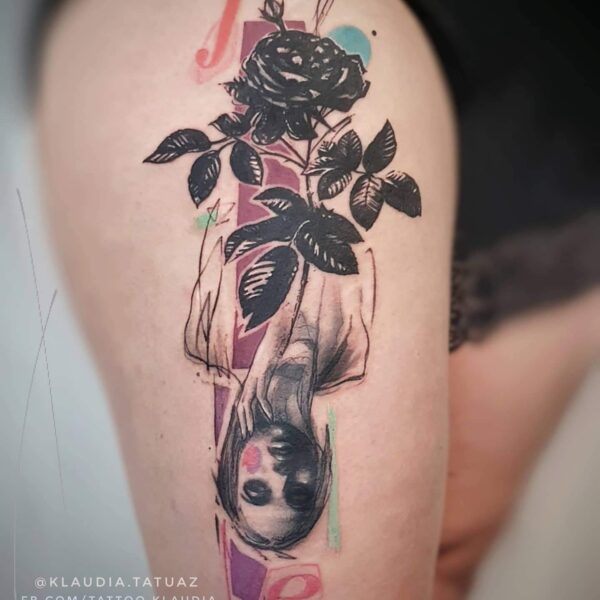 Abstract Black Rose Tattoo | Graphic Portrait Art | Silent Moon Tattoo Studio London Abstract black rose and inverted female portrait tattoo on thigh. Graphic blackwork with subtle colour accents tattooed at Silent Moon Tattoo Studio London UK.