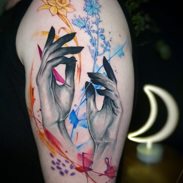 Abstract Watercolour Hands and Flowers Tattoo | Custom London Studio Art Abstract realism hands tattoo on arm holding line art flowers. Watercolour colour splashes by Silent Moon Tattoo Studio London UK.