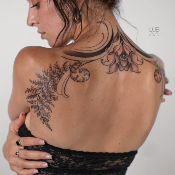 Ornamental floral back and neck tattoo with fine line details by tattoo artist at Silent Moon Tattoo Studio in London.