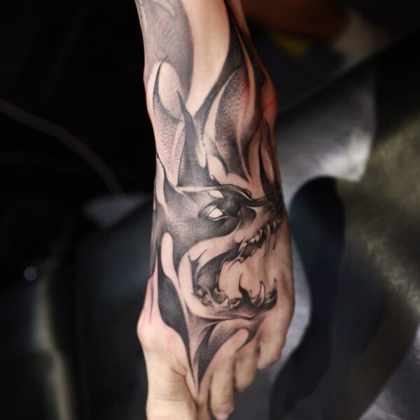 Custom dark art blackwork snarling wolf head tattoo on the top of the foot. Stylized black and grey animal portrait tattooed at Silent Moon Tattoo Studio London UK.